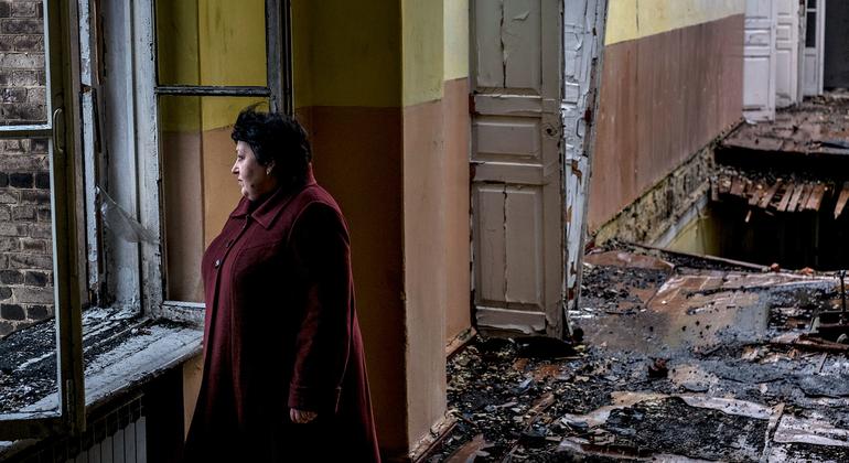 Mulher está em uma escola abandonada, danificada após um bombardeio, em Krasnohorivka, Donetsk, na Ucrânia